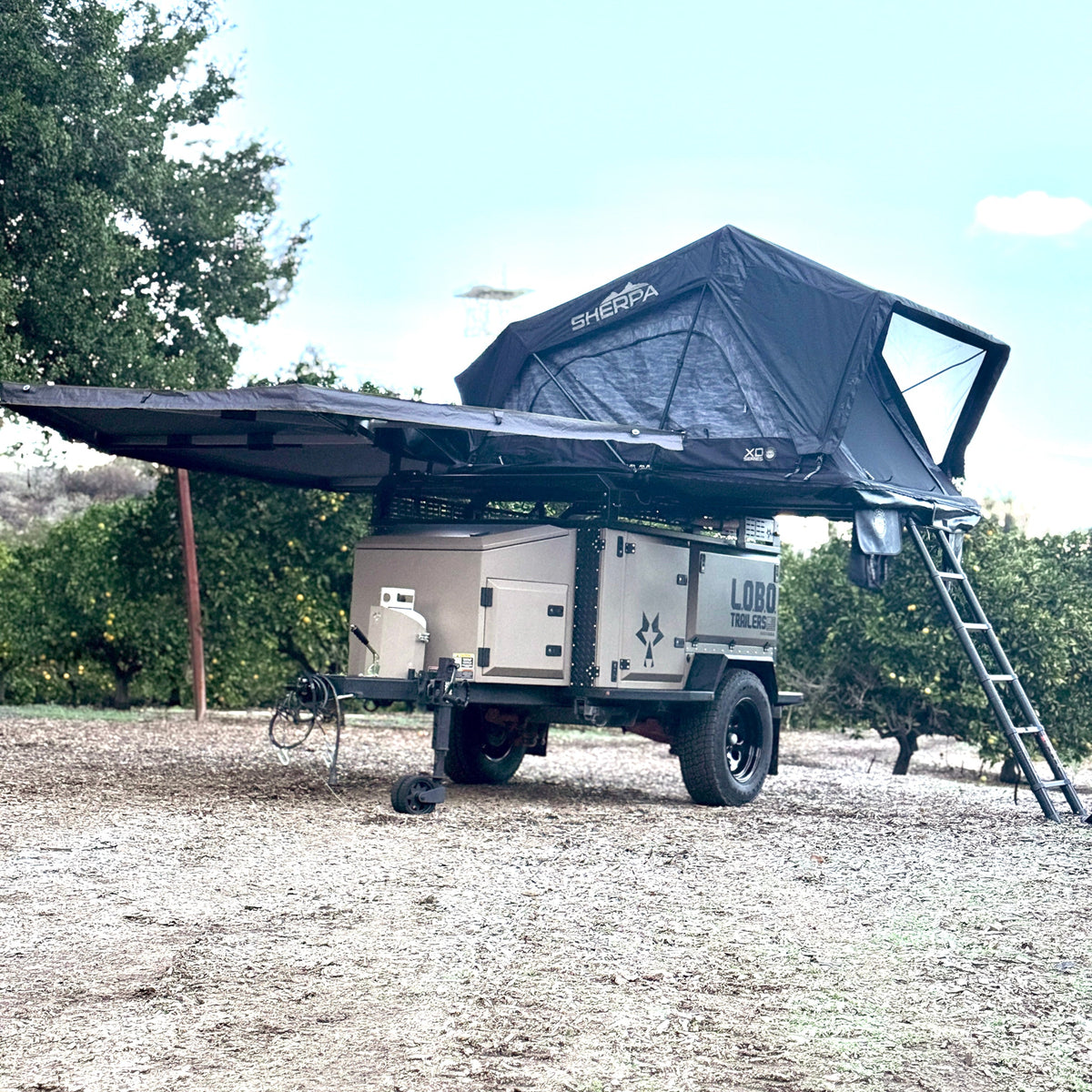 L.O.B.O. overland trailer with rooftop tent and awning deployed at a dirt campsite in Southern California